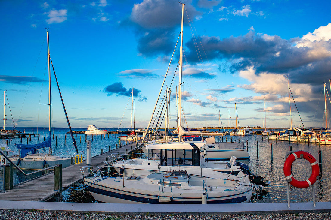 Electric boats docked at a modern marina with shore power pedestals ready for EV charging.